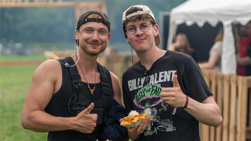 In einem halbseits geöffneten Container tanzen jungen Menschen vor einem DJ-Pult 