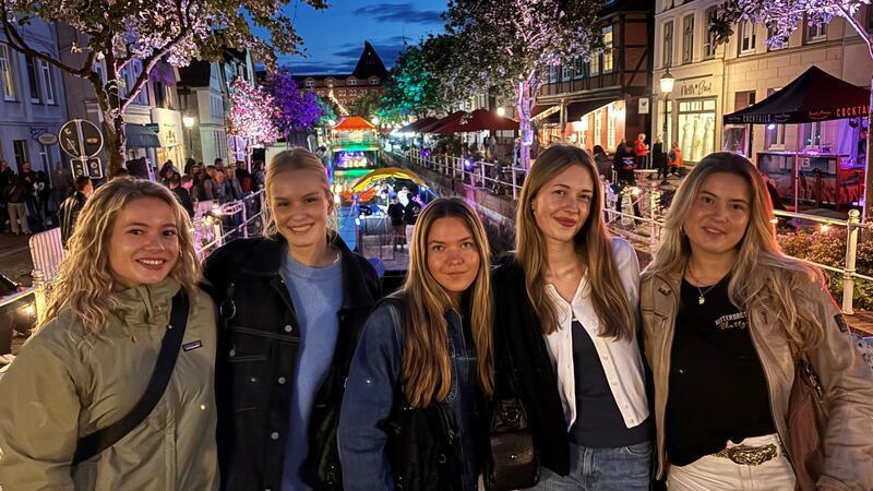 Besucherinnen des Fleth-Festes vor dem beleuchteten Fleth-Panorama.
