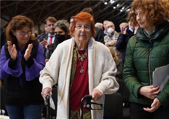 Die Gäste applaudieren Helga Melmed (l) aus den USA, Überlebende des KZ Neuengamme, nach ihrer Rede während der Gedenkfeier in der KZ Gedenkstätte Neuengamme zum 77. Jahrestag des Kriegsendes und der Befreiung der Häftlinge. Foto: Marcus Brandt/dpa