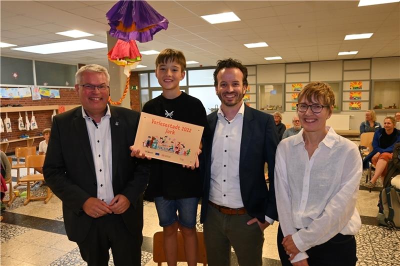 Die Gemeinde Jork ist eine „Vorlesestadt“: Bürgermeister Matthias Riel, Björn Meinholz („Die Zeit“) und Marika Klimainsky (Kita) nehmen Schüler Mats bei der Preisvergabe in Königreich in die Mitte. Foto: Vasel