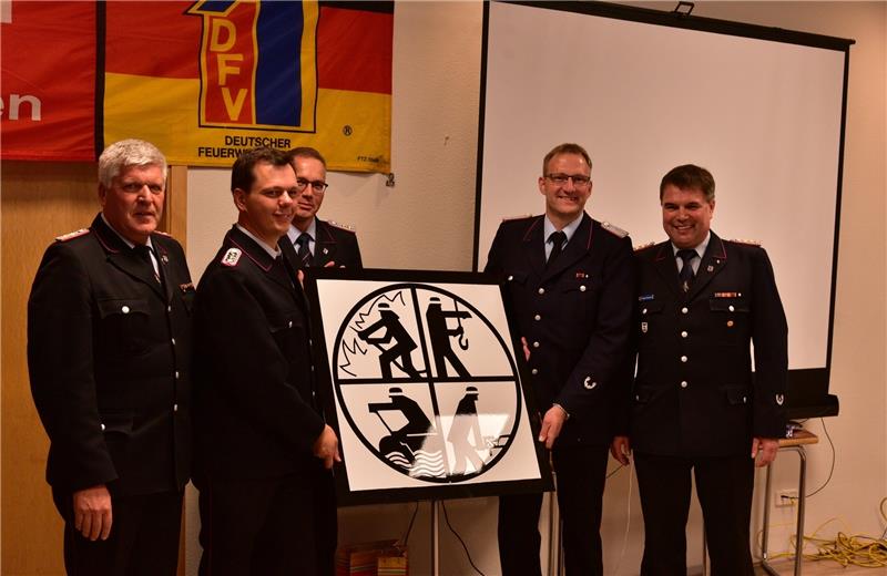 Die Gemeindebrandmeister überreichen eine Plakette fürs neue Feuerwehrhaus.