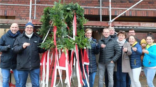 Die Geschäftsführer Johanna Kaller und Lutz Mosel (Dritte und Zweiter von links), stoßen mit Bürgermeisterin Sandra Lemmermann (Vierte von rechts), weiteren Mitwirkenden und zukünftigem Personal an.