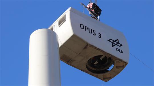 Die Gondel schwebt auf den Turm zu: Im DLR-Forschungspark Krummendeich wurde jetzt die Anlage Opus 3 aufgebaut.