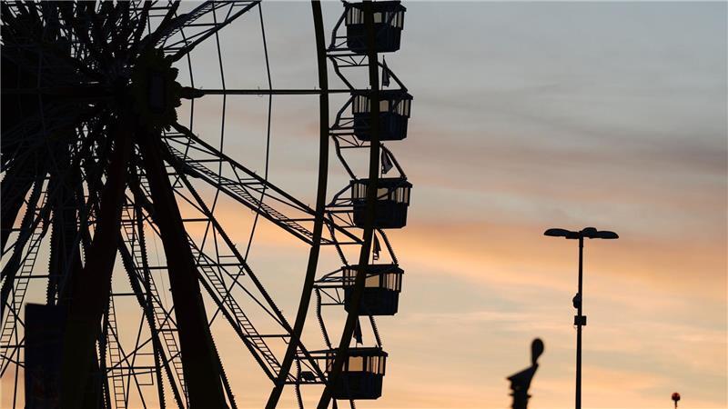 Die Gondeln vom Riesenrad auf dem Hamburger Winterdom auf dem Heiligengeistfeld sind vor dem Abendhimmel zu sehen. 