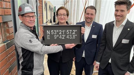 Die Grundsteinlegung für das erste Power-Townhouse-Projekt in Hollenstedt. Maurer Rainer Schmidt (von links) mit Bundesbauministerin Klara Geywitz sowie Dirk und Lars Viebrock.