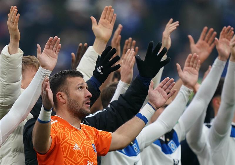 Die HSV-Spieler und Hamburgs Torhüter Daniel Heuer Fernandes jubeln nach Spielende mit den Fans. Foto: Marcus Brandt/dpa