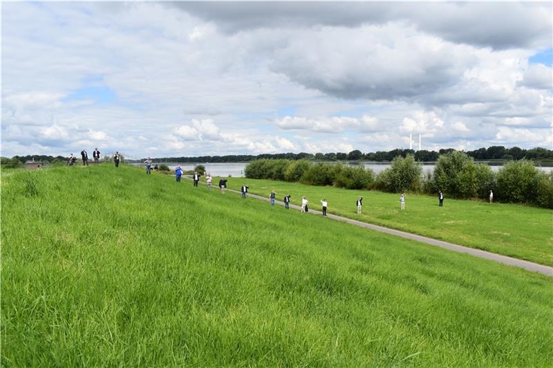 Die Hände der CDU-Landtagsabgeordneten sowie der Vertreter der Deichverbände und des Niedersächsischen Landesbetriebs für Wasserwirtschaft, Küsten- und Naturschutz zeigen, wie hoch der Deich an der Elbe in Jork-Hinterbrack ab 2022/2023 erhö