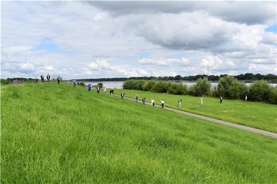 Die Hände der CDU-Landtagsabgeordneten sowie der Vertreter der Deichverbände und des Niedersächsischen Landesbetriebs für Wasserwirtschaft, Küsten- und Naturschutz zeigen, wie hoch der Deich an der Elbe in Jork-Hinterbrack ab 2022/2023 erhö