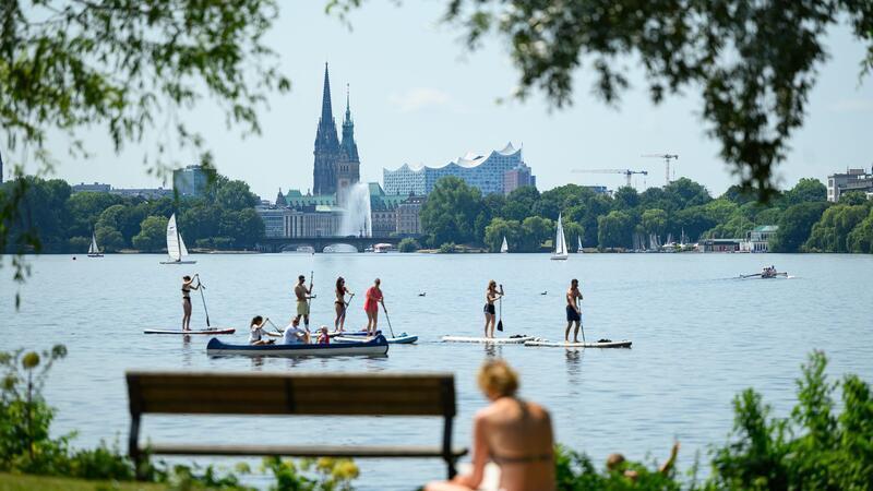 Die Hamburger Außenalster mit ihren Grünanlagen bietet bei sommerlicher Hitze Abwechslung und Abkühlung. (Archivbild)