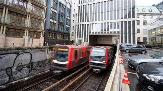 Hamburg: Zwei Bahnen der U-Bahn-Linie 3 fahren zwischen den Haltestellen Rathausmarkt und Rödingsmarkt aus und in einen Tunnel.