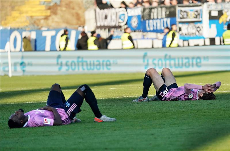 Die Hamburger Khaled Narey (l) und Adrian Fein liegen nach dem Unentschieden gegen Darmstadt auf dem Rasen. Foto: Hasan Bratic/dpa