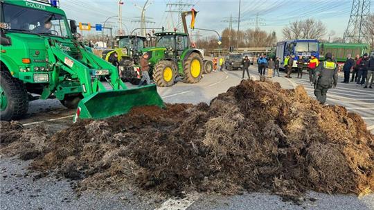 Die Hamburger Polizei räumt mit einem Unimog einen Misthaufen vom Finkenwerder Ring.