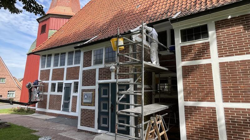 Die Handwerker arbeiten mit Hubsteiger und Gerüst.