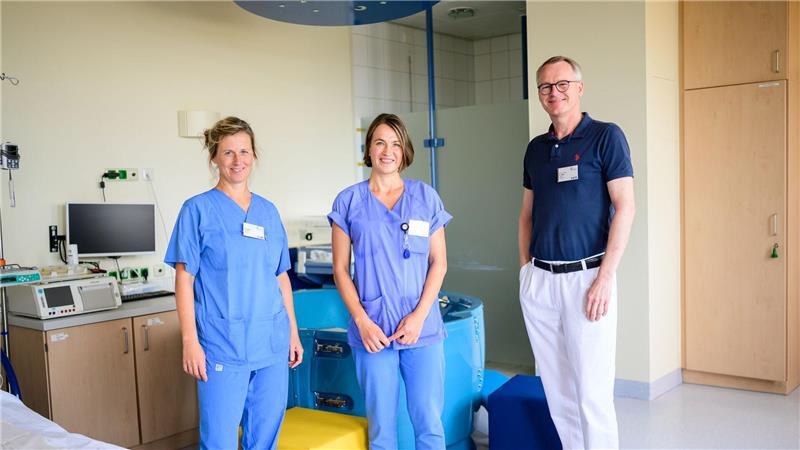 Die Hebammen Franziska Pfeil (l-r) und Antje Kuhrau sowie Peter Dall, Chefarzt, stehen in einem Kreißsaal des Klinikums Lüneburg. Seit diesem Monat können Frauen in Begleitung von zwei Hebammen entbinden.