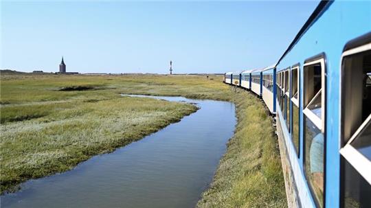 Die Inselbahn fährt über die Salzwiesen und bringt Urlauber von der Fähre zum Bahnhof.