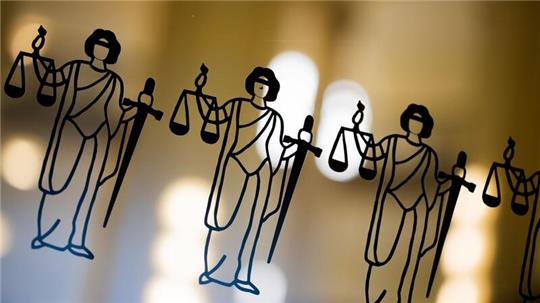 Die Justitia ist an einer Scheibe am Eingang zum Oberlandesgericht zu sehen.