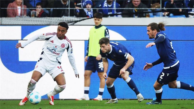 Düsseldorf gewinnt nach 0:2 noch 3:2 in Karlsruhe Die KSC-Spieler Leon Jensen (m) und Sebastian Jung (r) attackieren den Düsseldorfer Myron van Brederode (l).