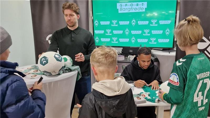 Die Kinder freuen sich über die Autogrammstunde mit den Werder-Profis Felix Agu und Mitchell Weiser (links).