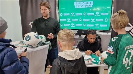 Die Kinder freuen sich über die Autogrammstunde mit den Werder-Profis Felix Agu und Mitchell Weiser (links).