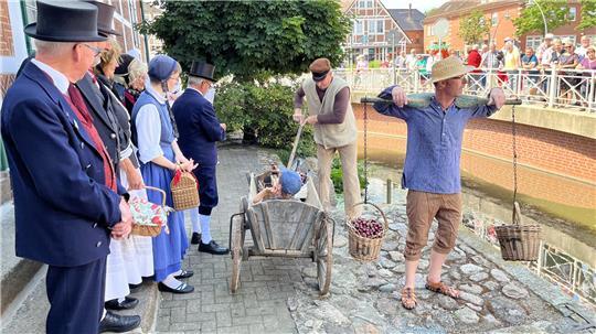 Die Kleine Jorker Bühne und die Altländer Gästeführung begrüßen die Gäste des Kirschmarktes an der Wettern vor dem Gräfenhof.