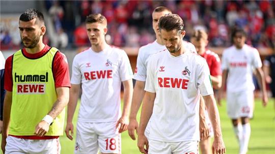 Die Kölner Spieler gehen nach der Niederlage in Heidenheim mit hängenden Köpfen vom Rasen.