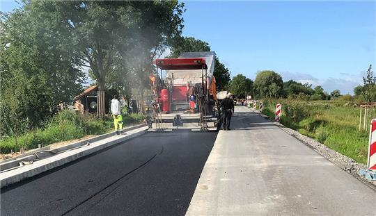 Die Kreisstraße 39 in Jork-Borstel bekommt eine neue Asphaltschicht. Ein Bauarbeiter ist bei einem Unfall auf dem gesperrten Streckenabschnitt verletzt worden. Foto: Landkreis Stade/Winkler