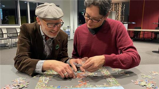 Die Künstler Ulrich Schaper und Reiner Sprenger puzzeln ihr Wimmelwerk von Buxtehude zusammen.