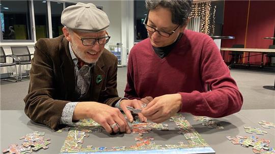 Die Künstler Ulrich Schaper und Reiner Sprenger puzzeln ihr Wimmelwerk von Buxtehude zusammen.