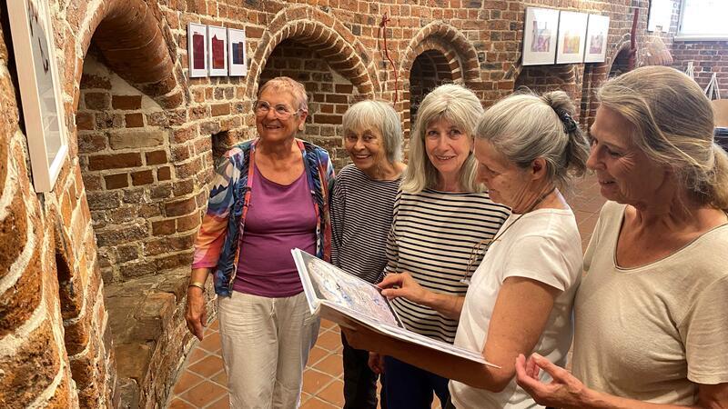 Die Künstlerinnen Marlene Apmann, Birgit Jaenicke, Imke Korth-Sander und Barbara Uebel stehen mit Kulturpädagogin Jutta de Vries (von rechts) gemeinsam vor einem der Werke 