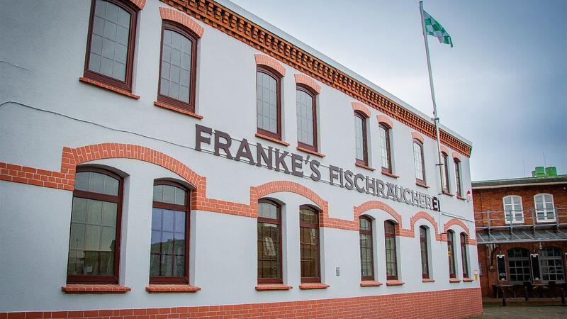 Die Ladenfront zum Hafenbecken ist inzwischen ikonisch. Stets ist die Flagge des Fußballvereins Werder Bremen gehisst.