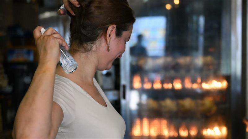 Die Ladeninhaberin schwört zur Erfrischung auf Mentholspray. 