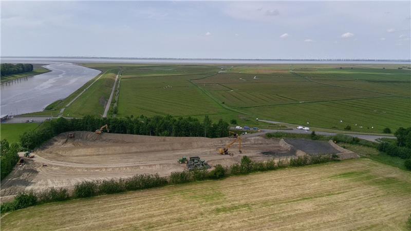 Ärger um Hafenschlick-Depot an der Oste: Lager ohne Genehmigung gebaut Die Lagerfläche wird mit Hafenschlick (rechts im Bild) gefüllt. Links die Ostemündung, hinter der Baumreihe beginnt das Wildvogelreservat Nordkehdingen, das sich bis zur Elbe erstreckt.