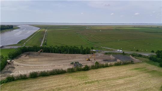 Die Lagerfläche wird mit Hafenschlick (rechts im Bild) gefüllt. Links die Ostemündung, hinter der Baumreihe beginnt das Wildvogelreservat Nordkehdingen, das sich bis zur Elbe erstreckt.