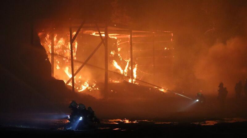 Die Lagerhalle steht lichterloh in Flammen. Die Einsatzkräfte bekämpfen das Feuer.