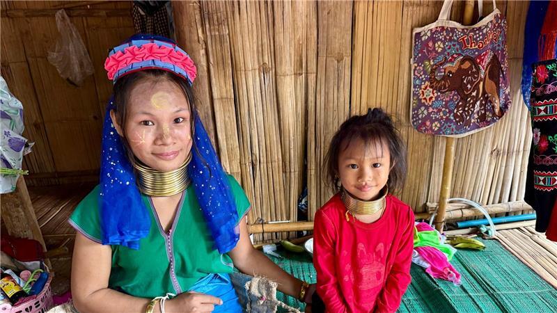 Bei den Langhalsfrauen von Chiang Rai: Kultur oder Kommerz? Die Langshalsfrauen und ihre Kinder sind daran gewöhnt, für Touristenfotos in die Kameras zu lächeln.