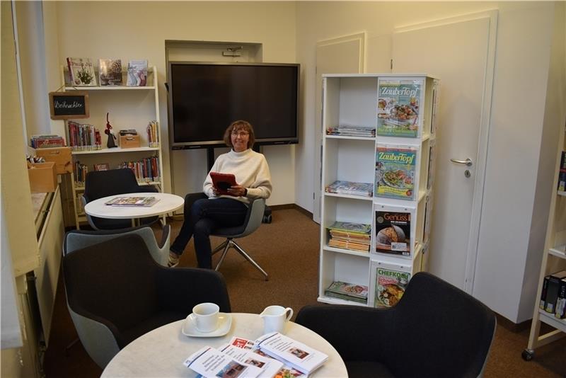 Die Leiterin der Gemeindebücherei Steinkirchen-Grünendeich, Petra Abel, hat es sich auf einem der Sessel im neuen Lesecafé – mit einem der fünf neuen I-Pads, bequem gemacht. Foto: Vasel
