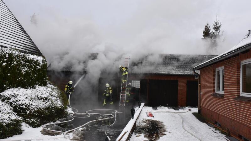 Die Feuerwehr löscht in in Brand stehende Garage.