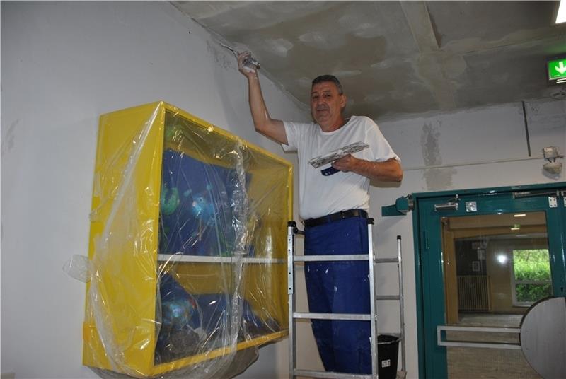 Die Malerarbeiten der Oberschule Horneburg sind in vollem Gang: Zoran Velickovic spachtelt die Decke im Flur im Erdgeschoss. Auch die Wände und Fußböden werden erneuert. Foto Lohmann