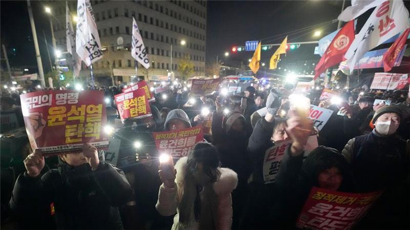 Bericht: Mehrere Minister in Südkorea wollen zurücktreten Die Menge vor dem Parlament protestierte lautstark gegen Yoons Vorgehen.