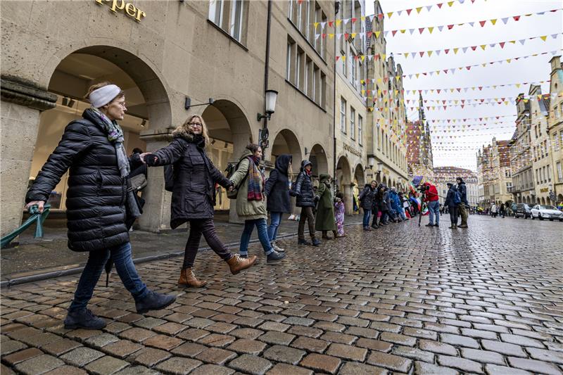 Stader demonstrieren für Frieden – „Habe Angst“ Die Menschenkette auf dem Prinzipalmarkt in Münster. Foto: Christoph Reichwein/dpa