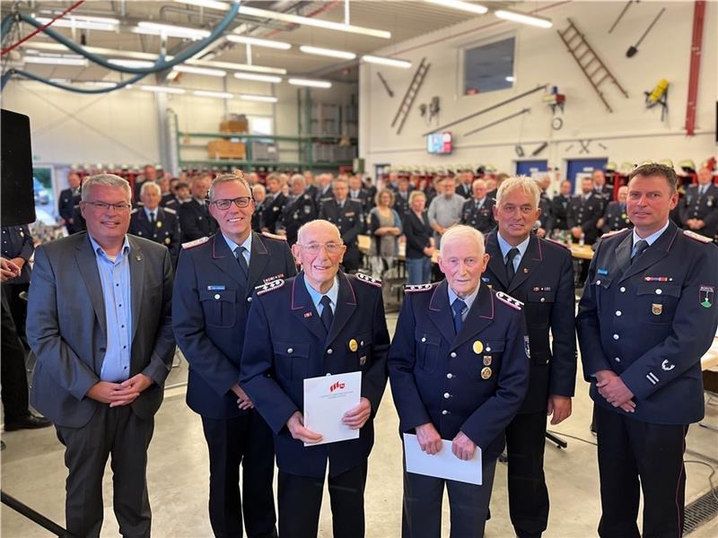 Die Mitglieder der Feuerwehr der Gemeinde Jork erheben sich zu Ehren von Walter zum Felde und Günter Lühders (vorne) aus Ladekop. Foto: Vasel