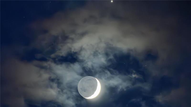 Die Mondsichel mit der Venus am frühen Abendhimmel (Illustration).