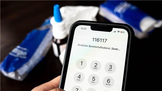 Die Nummer des Ärztlichen Bereitschaftsdienstes 116117 ist auf einem Smartphone zu sehen.