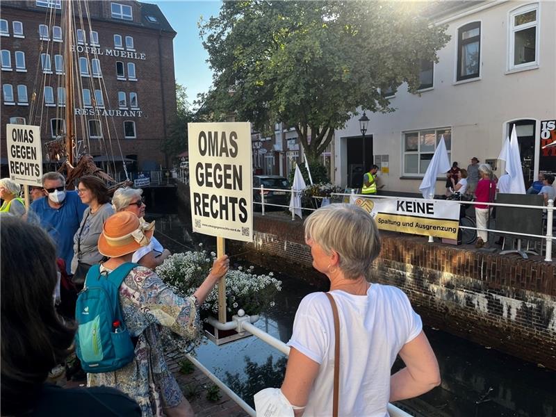 Omas gegen Rechts und Buxaktiv streiten bei Demo am Fleth Die Omas gehen Rechts singen gegen braunen Sumpf, Buxaktiv schwenkt weiße Fahnen und skandiert gegen die Corona-Impfung. Foto: Richter