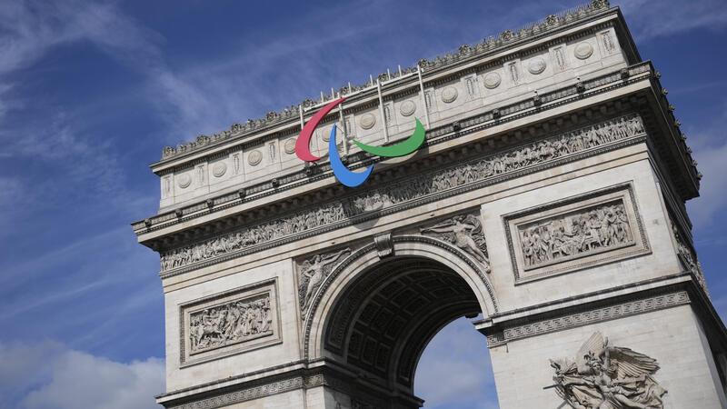Paralympics in Paris: Sportarten, Chancen und Prämien, Live-TV Das Symbol der Paralympischen Spiele hängt am Arc de Triomphe.