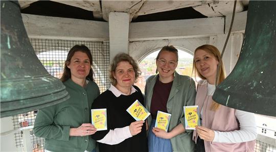 Die Pastorinnen Heike Kircher, Dorlies Schulze, Mira Neckel und Vikarin Marielle Seligmann werben auf dem Turm der Liebfrauenkirche in Horneburg für die Aktion „Einfach Heiraten“ (von links).