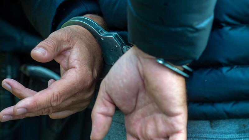 Ein Mann trägt Handschellen