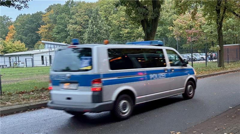 Die Polizei auf dem Weg zum Einsatz in Sachen Jugendbande. Im Hintergrund das Jubs.