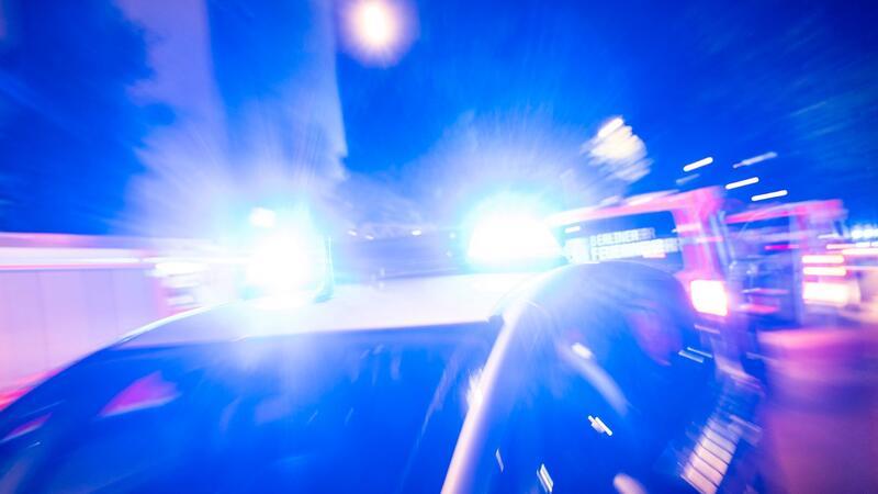 Ein Streifenwagen der Polizei steht mit Blaulicht an einem Einsatzort.