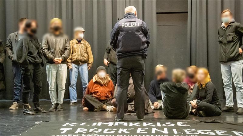 Die Polizei fordert am Dienstabend die jungen Besetzer und Klimaaktivisten auf, die Aula der Schollschule zu verlassen. Foto: Scheschonka
